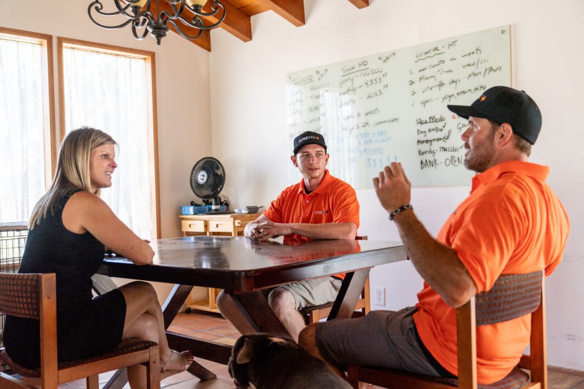 two pros sitting at a table with a customer