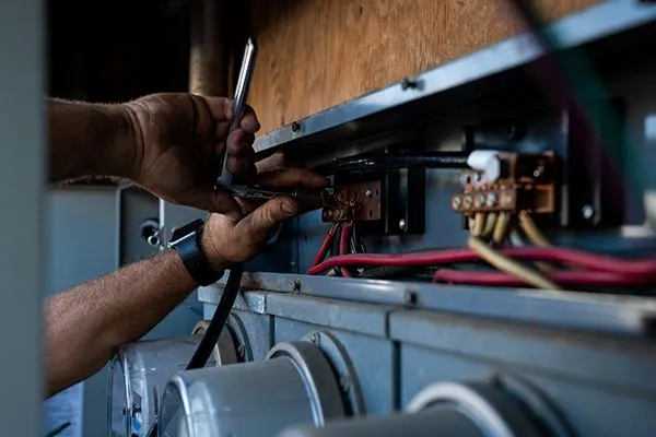 Electrician works on wires in electrical box